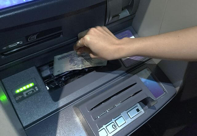 Đưa tiền vào khe dưới màn hình máy ATM 