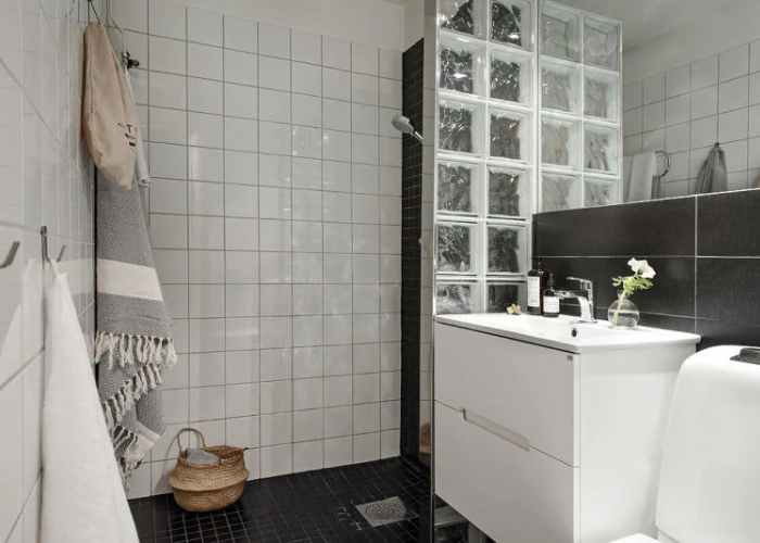 Sàn phòng tắm 2m2 được lát bằng gạch nhỏ hạn chế trơn trượt, tông màu tối tạo cảm giác rộng rãi