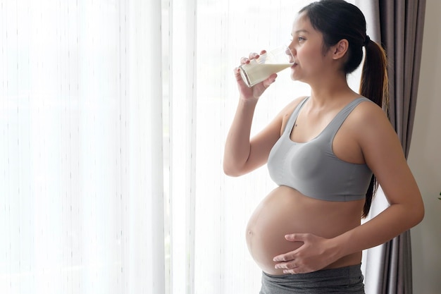 Premium Photo | Young pregnant woman drinking milk at home healthcare and  pregnancy care
