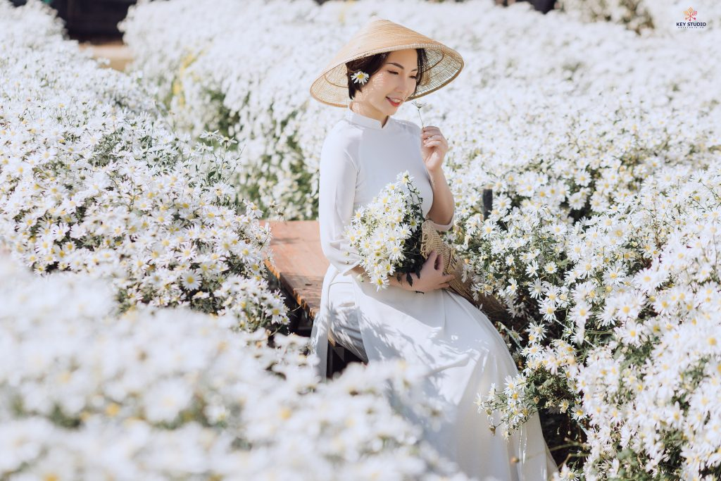 Tạo dáng chụp ảnh ở vườn hoa sử dụng hoa làm tiền cảnh nổi bật chủ thể (Nguồn: Internet)