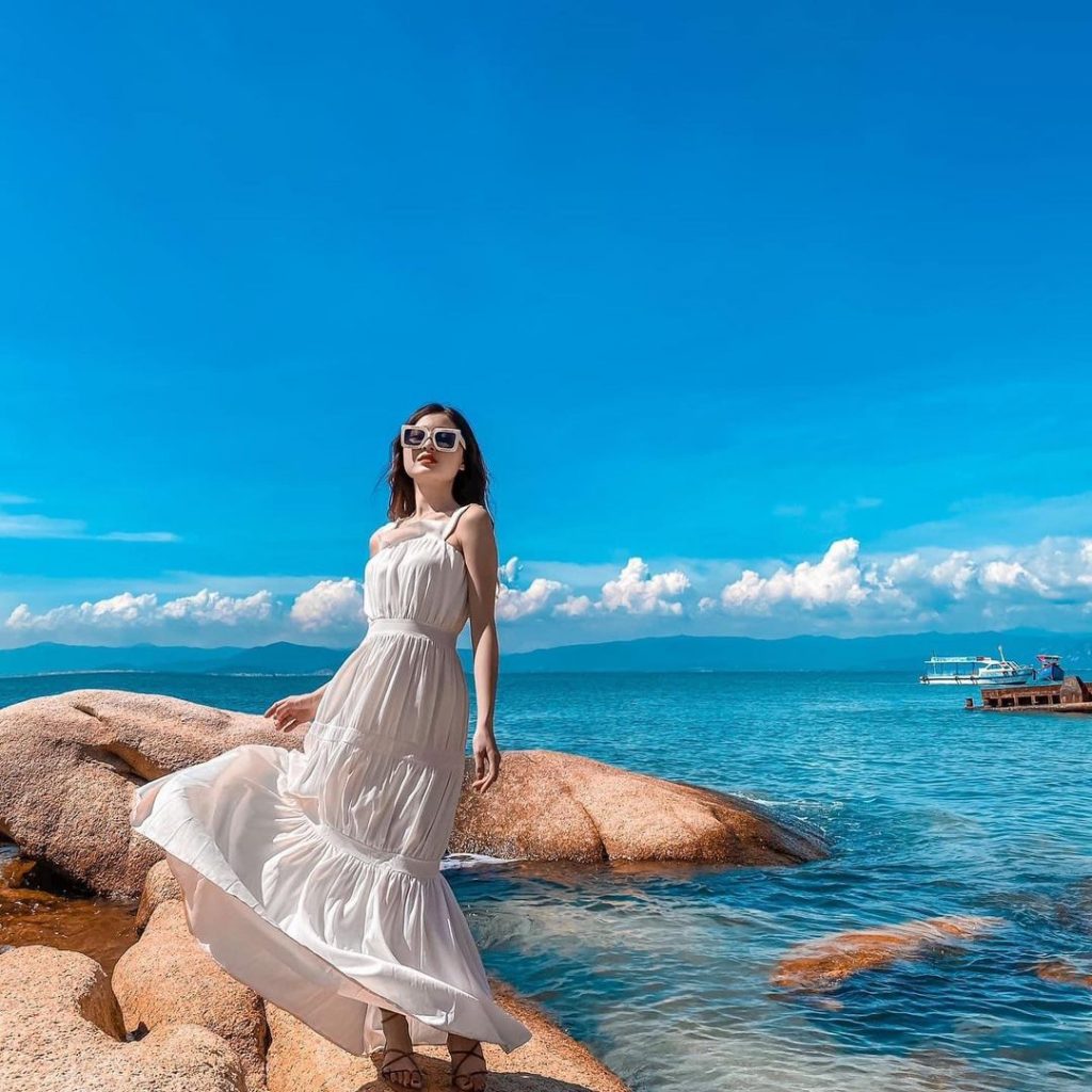 Cách tạo dáng chụp ảnh đẹp khi mặc váy đi biển bằng cách hất nhẹ tà váy tung trong gió (Nguồn: Internet)